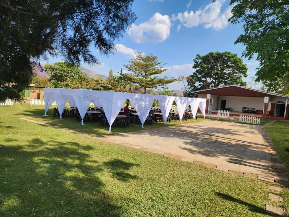 Wide view of a white event tent and the Ma Nkosi garden venue