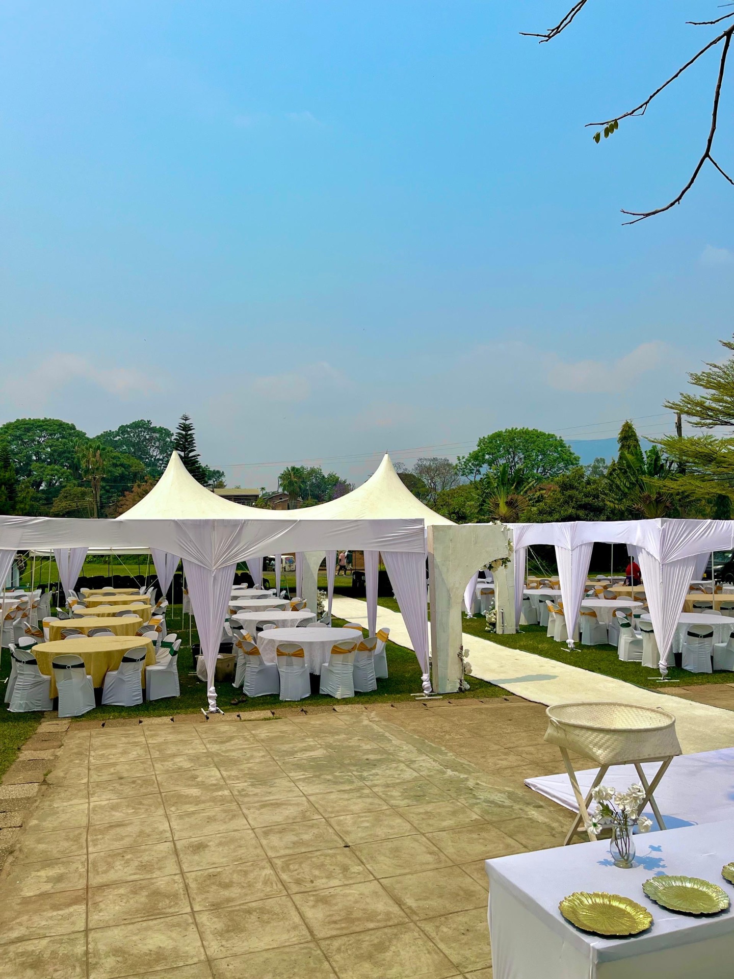 Dressed white event tents with round tables and seating in the garden